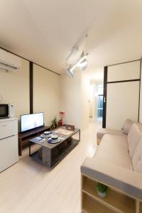 a living room with a couch and a table at なんばや心斎橋にも直結の最大8名宿泊可能の広々メゾネット JPtrad 桔梗 in Osaka