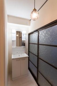 a bathroom with a sink and a mirror at なんばや心斎橋にも直結の最大8名宿泊可能の広々メゾネット JPtrad 桔梗 in Osaka