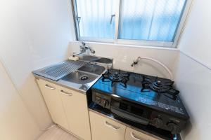 a small kitchen with a stove and a sink at なんばや心斎橋にも直結の最大8名宿泊可能の広々メゾネット JPtrad 桔梗 in Osaka +20 photos