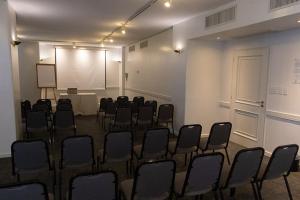 a conference room with chairs and a white screen at Comodoro Hotel in Comodoro Rivadavia