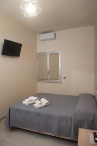 a bedroom with a bed with two towels on it at ASARO Camere in Campobello di Licata