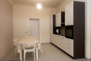 a kitchen with a table and chairs in a room at ASARO Camere in Campobello di Licata
