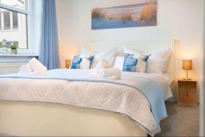 a bedroom with a bed with a doll on it at RegioStyle-Apartment-mit-Meerblick-Balkon-Strand in Eckernförde