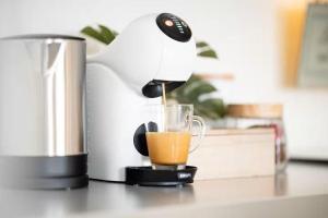 a coffee maker is making a drink in a glass at RegioStyle-Apartment-mit-Meerblick-Balkon-Strand in Eckernförde