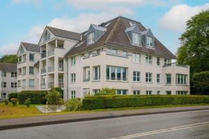 a large white apartment building with a roof at RegioStyle-Apartment-mit-Meerblick-Balkon-Strand in Eckernförde