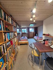 a library with a table and chairs and books at "Mon Rêve" Nature, Tranquility & Lake Thun in Sigriswil +19 photos