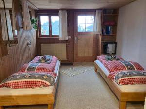 a bedroom with two beds and a tv in it at "Mon Rêve" Nature, Tranquility & Lake Thun in Sigriswil
