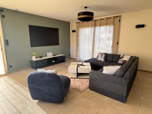 a living room with two couches and a flat screen tv at Maison au calme à Pont-Évêque in Pont-Évêque