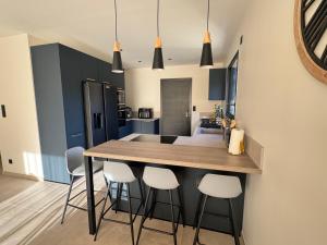 a kitchen with a island with bar stools at Maison au calme à Pont-Évêque in Pont-Évêque