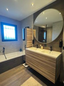 a bathroom with two sinks and a tub and a mirror at Maison au calme à Pont-Évêque in Pont-Évêque +9 photos