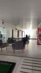 a living room with couches and tables in a building at Hotel Estação Brejal in Brejo Santo