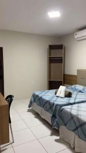 a bedroom with a bed and a chair in it at Hotel Estação Brejal in Brejo Santo