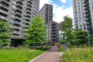 a sidewalk in a city with tall buildings at Cozy and Spacious Central London room in Canary Wharf Flat with a City View & a Private Bathroom in London