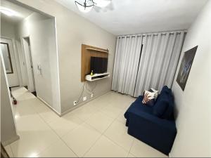 a living room with a blue couch and a television at Apartamento próximo Santa Casa e ABQM in Araçatuba