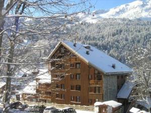 a large building in the snow with a mountain at Charmant 2 pièces mezzanine, 6 pers, centre Méribel, proche pistes et commerces - FR-1-180-364 in Les Allues