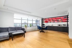 a living room with a couch and a table at Cozy and Spacious Central London room in Canary Wharf Flat with a City View & a Private Bathroom in London
