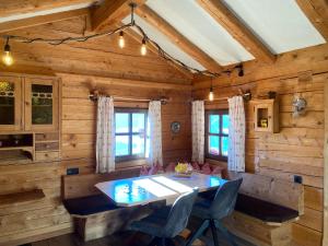 a dining room in a log cabin with a table and chairs at Sonnberg Apartment in Niedernsill