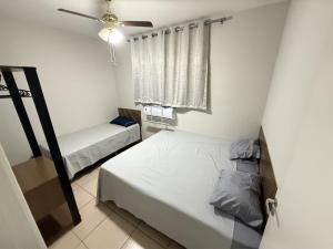 a bedroom with two beds and a ceiling fan at Apartamento próximo Santa Casa e ABQM in Araçatuba +7 photos
