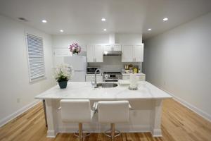 a kitchen with white cabinets and a large white island at Spacious and Brand New Apartment in Point Breeze - Prime Location in Philadelphia