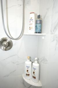 a bathroom with two bottles of toiletries on a shelf at Spacious and Brand New Apartment in Point Breeze - Prime Location in Philadelphia +38 photos