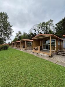 a row of wooden huts in a park at Camping Deva in Deva