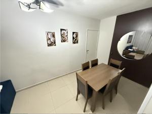a dining room with a table and a mirror at Apartamento próximo Santa Casa e ABQM in Araçatuba