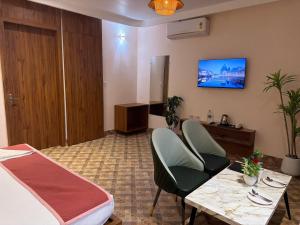 a room with a bed and a table and chairs at Hotel Advika in Kaithal