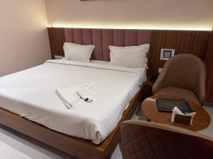 a bedroom with a bed with a chair and a laptop at Hotel Advika in Kaithal +43 photos