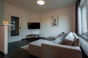 a living room with a couch and a flat screen tv at Appartement Wim in Blankenberge
