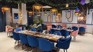 a dining room with tables and blue chairs at Hotel Advika in Kaithal