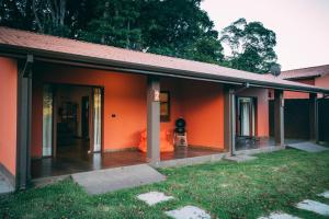 a house with orange walls and an open door at Paineira Vila Flat in Paraisópolis