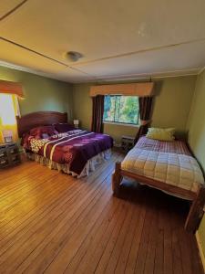 a bedroom with two beds and a window at Casona de Campo in Puerto Varas