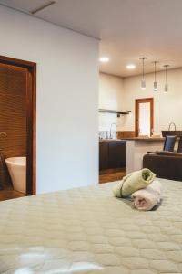 a large bed in a room with a bathroom at Paineira Vila Flat in Paraisópolis