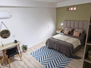 a bedroom with a bed with a blue and white rug at Estudio Villa Rosas in Rafaela
