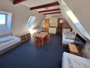 a room with two beds and a table and chairs at Penzion U Vorlíčků in Jablonné nad Orlicí