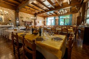 a dining room with tables and chairs in a restaurant at Villaggio Hotel Aquila in Calliano