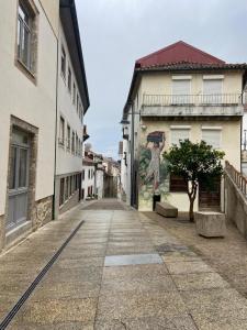 an empty street with a mural on the side of a building at Casa do Pelourinho in Arcos de Valdevez