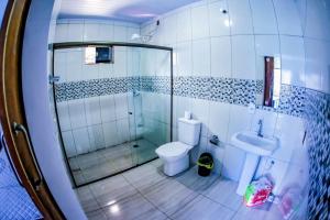a bathroom with a shower and a toilet and a sink at Casa grande com piscina área gourmet in Cascavel