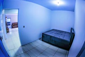 a room with a bed in the corner of a room at Casa grande com piscina área gourmet in Cascavel