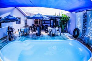 a jacuzzi tub in a patio with tables and chairs at Casa grande com piscina área gourmet in Cascavel