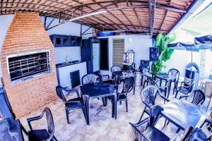 a dining room with tables and chairs and a fireplace at Casa grande com piscina área gourmet in Cascavel