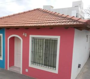 a red and white house with a gate at Departamentos Tere in Las Grutas