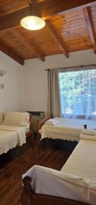 a bedroom with two beds and a large window at Casa Pier Giorgio in El Chalten