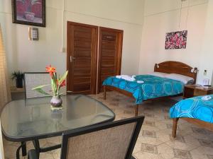 a room with a table and a bed and a bedroom at Fernando'S Seaside Guest House in Sarteneja