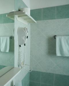 a bathroom with a hair dryer hanging on the wall at Hotel leonardo in Cattolica +42 photos