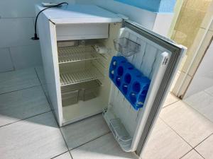 a small refrigerator with its door open in a room at Sol e Mar BC in Balneário Camboriú