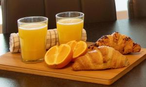 a wooden cutting board with two glasses of orange juice at Rook View in Buckie