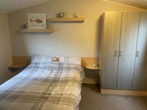 a bedroom with a bed and a wooden cabinet at 26 The Green Captains Cabin in Crantock +20 photos
