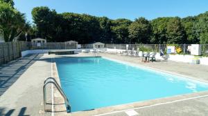 a large swimming pool with a picnic table and chairs at 26 The Green Captains Cabin in Crantock