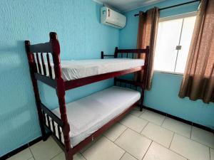 two bunk beds in a room with a window at Sol e Mar BC in Balneário Camboriú